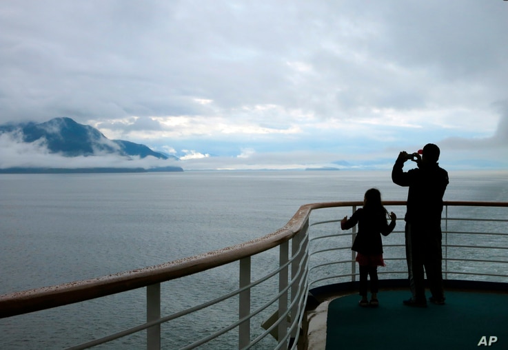 FILE - In this July 28, 2014, file photo, a cruise ship passenger takes photos of Alaska's Inside Passage. The Canadian